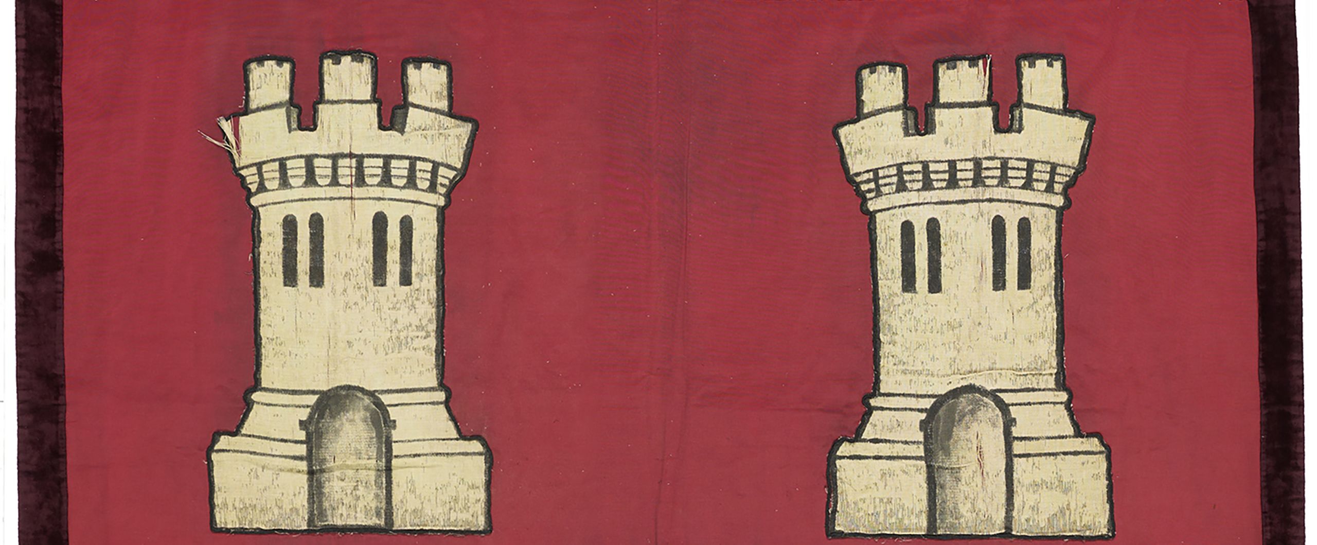 Section taken from Ethel Williams' suffragist marching banner, with a rich red background and two castle turrets on either side of the image