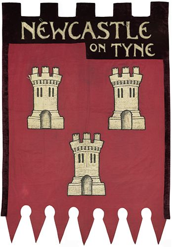 Suffragette marching banner with 'Newcastle on Tyne' across the top, with 3 turrets of Newcastle Castle on a maroon background