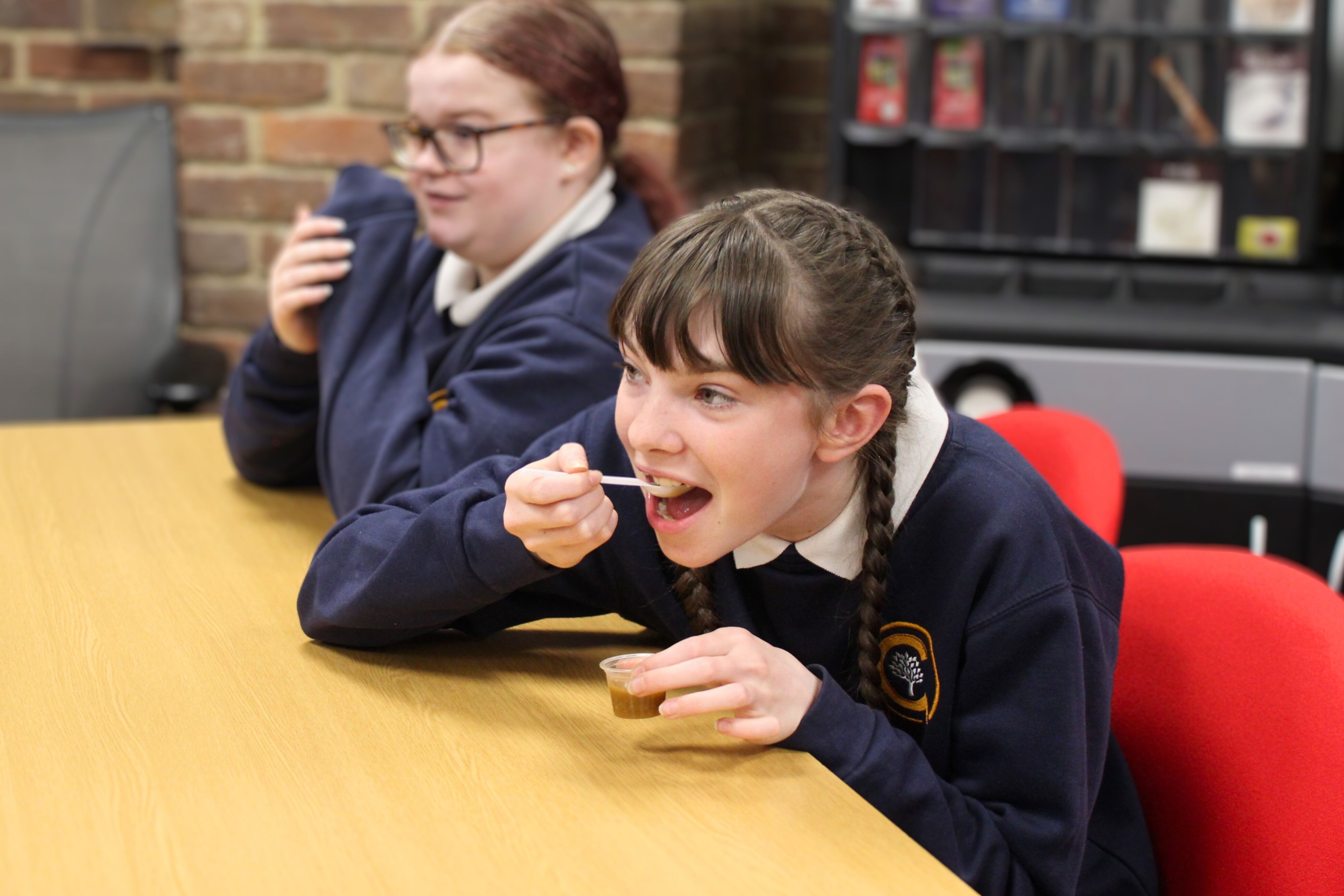 A student holding a spoon to their mouth