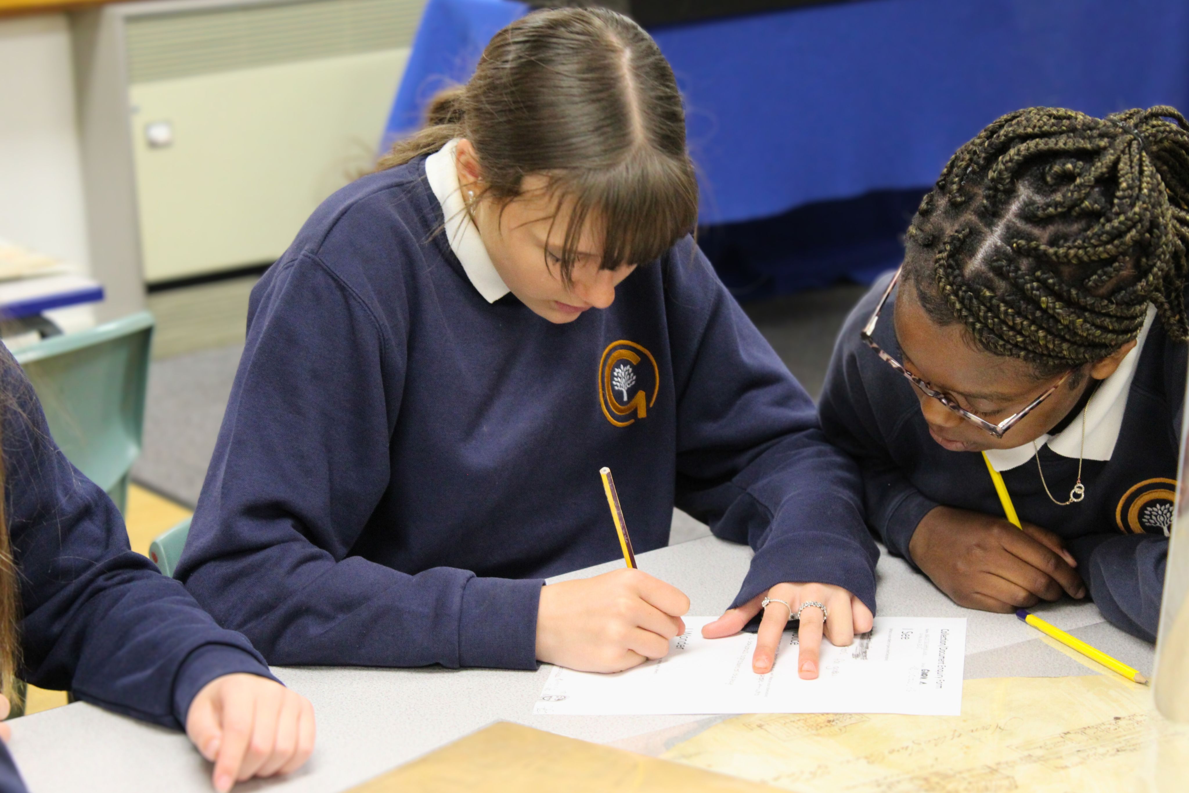 Two students looking at a worksheet and holding a pencil