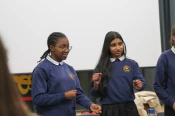 A student poised with their fists in front of them during a drama activity