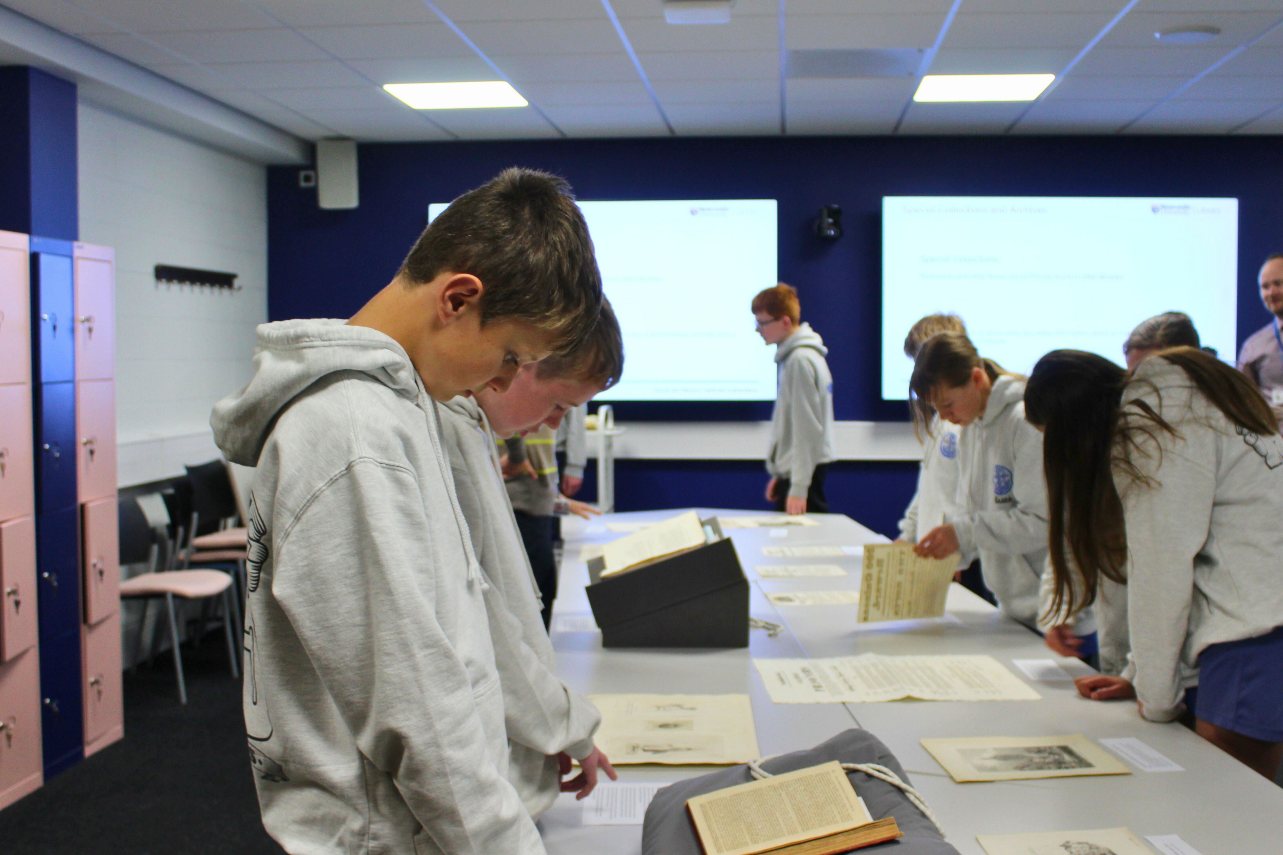 Two students looking down at books and papers
