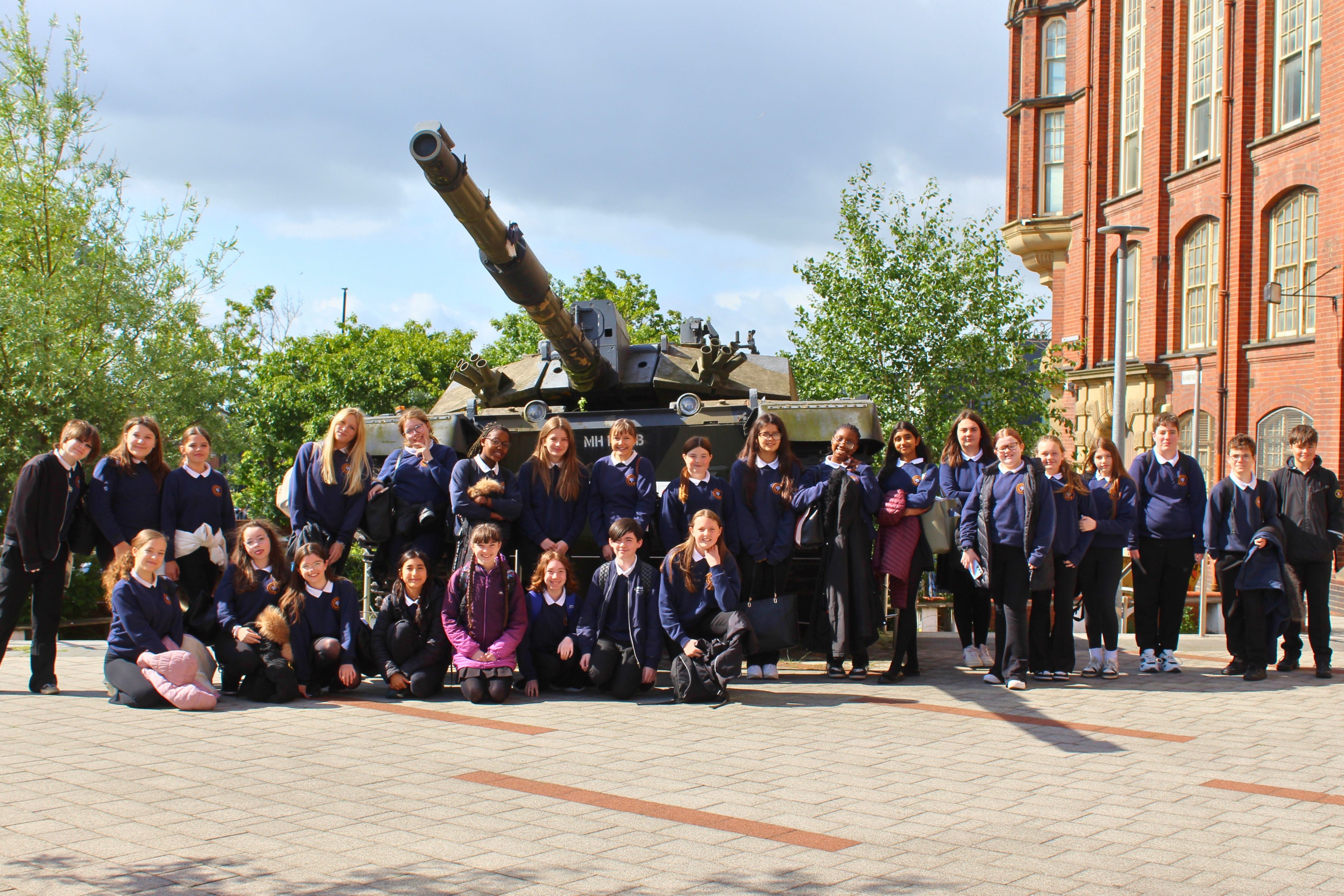 Students gathered in front of a tank