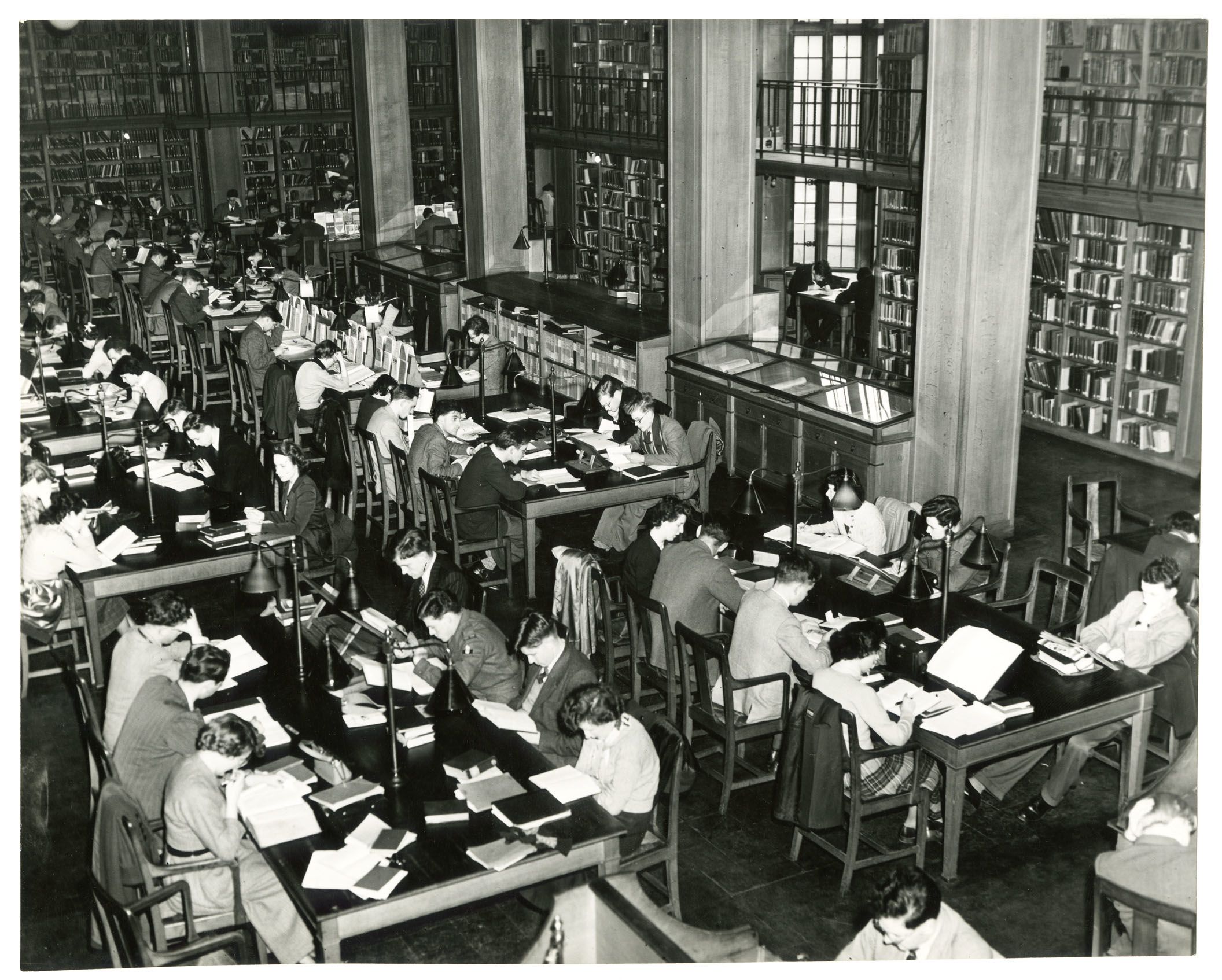 Students studying in the 1960s Library at large group desks.