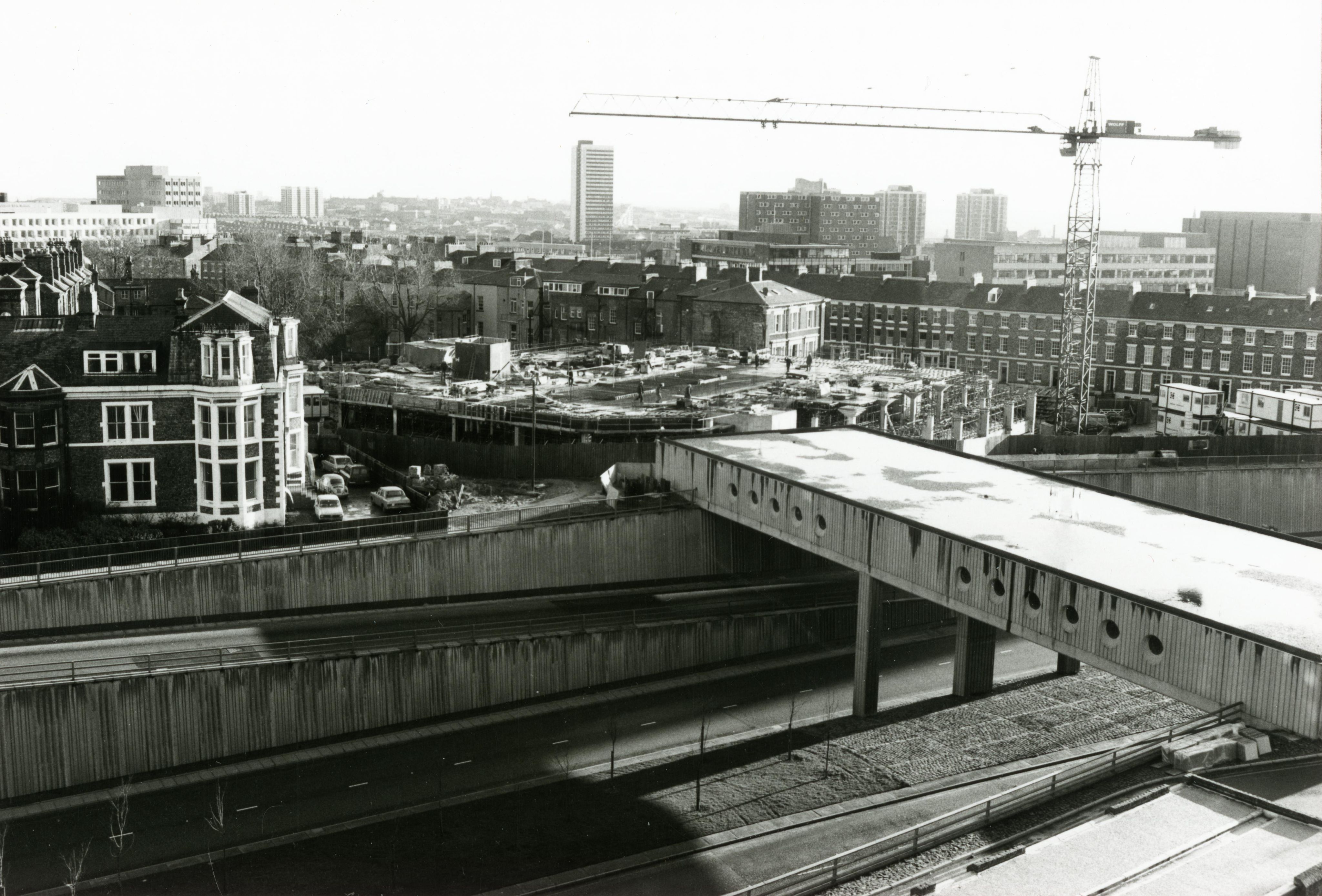 Construction site with a crane and concrete foundations.