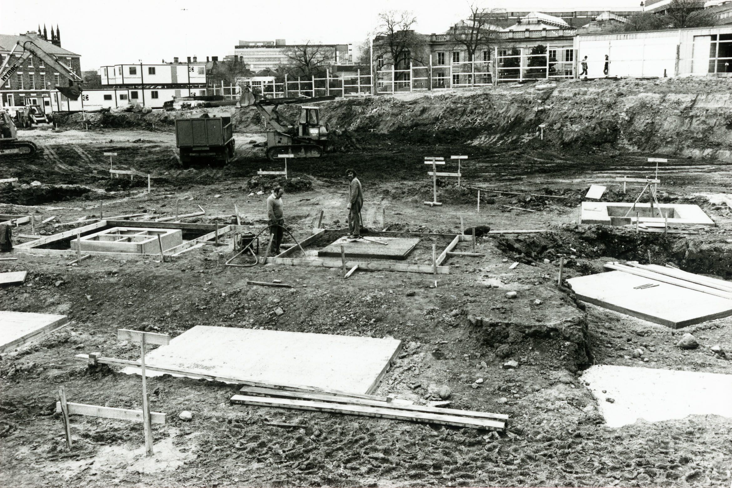 Workmen laying concrete foundations. 