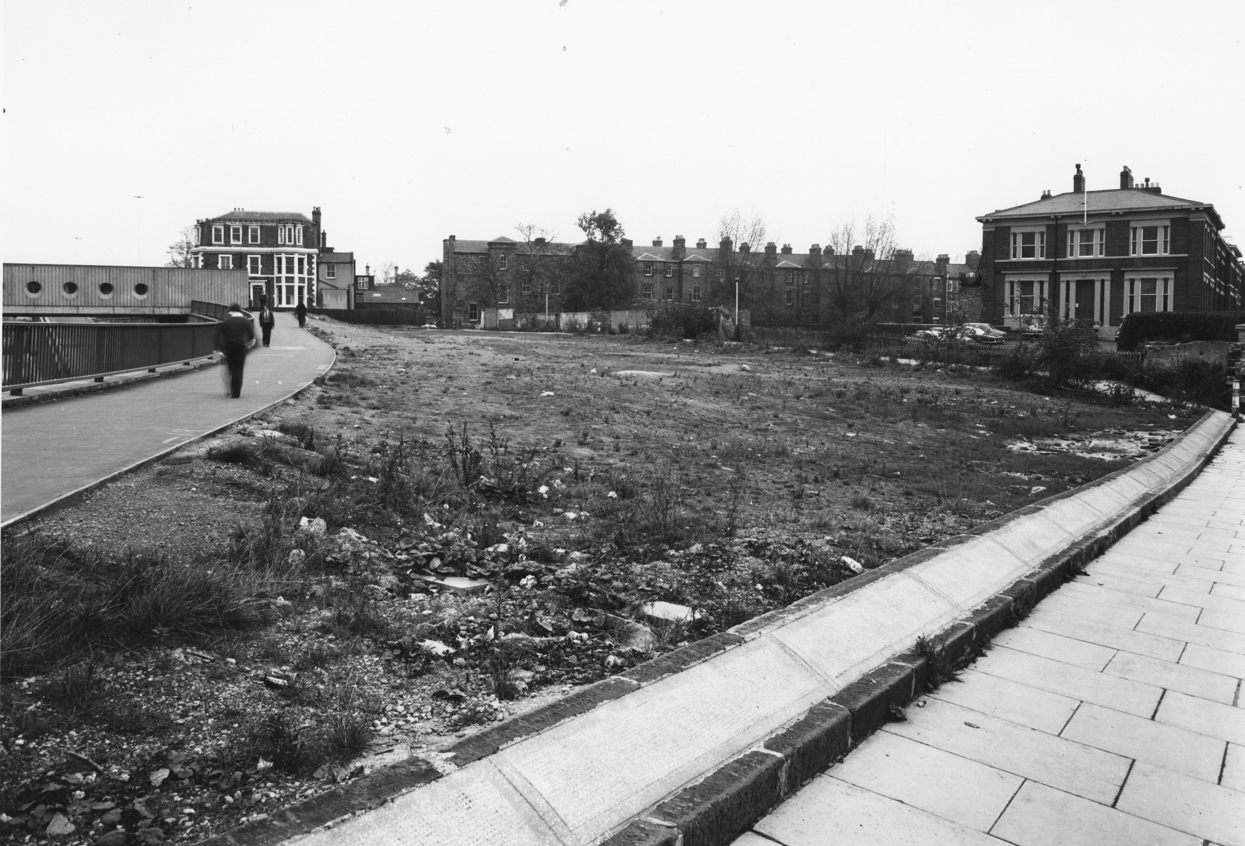 Open land with students walking along a path. 