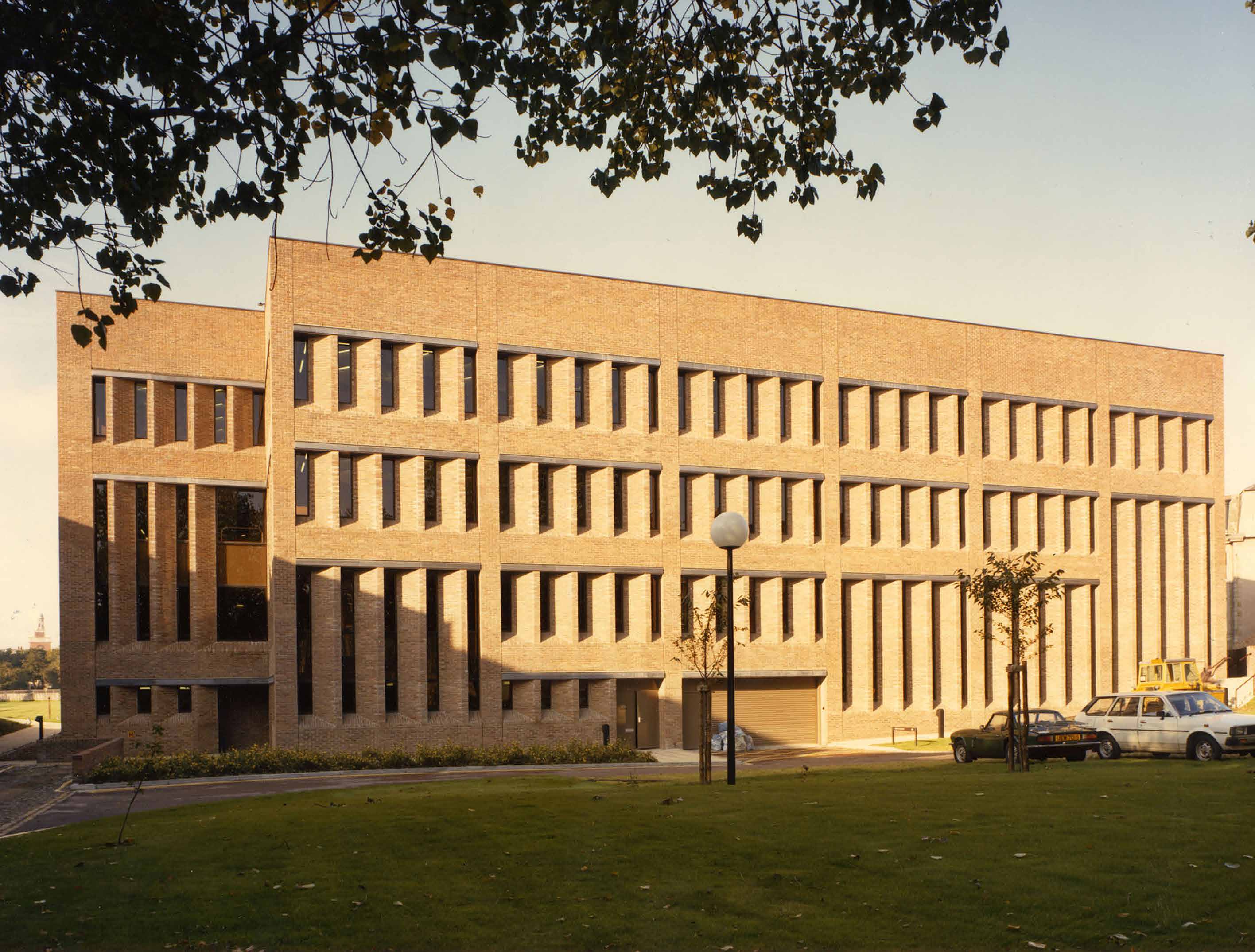 Exterior view of the Library with two parked cars, 1986.