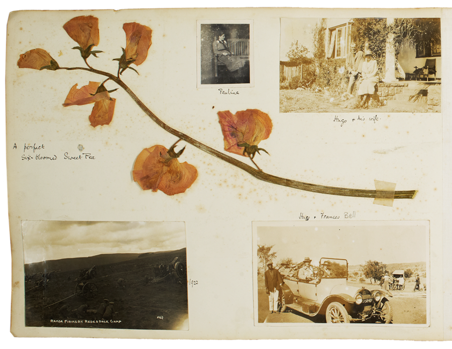 Page from a family photograph album with family photographs and a sweet pea cutting