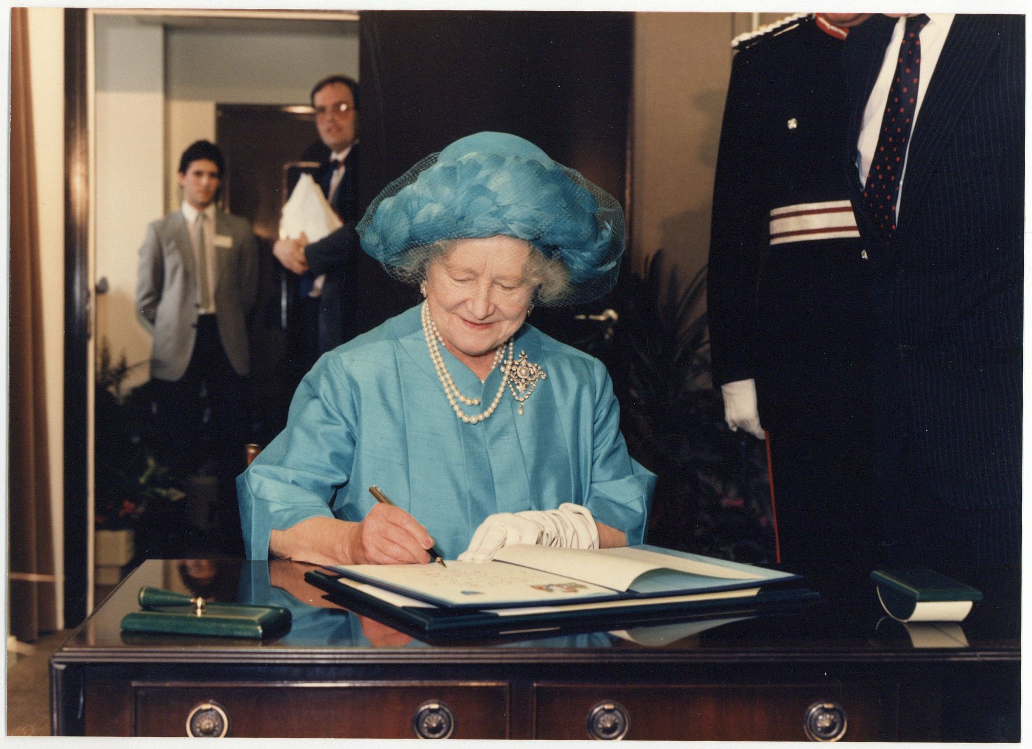 Photograph of the late Queen Mother signing the book for the opening of the new Medical School.