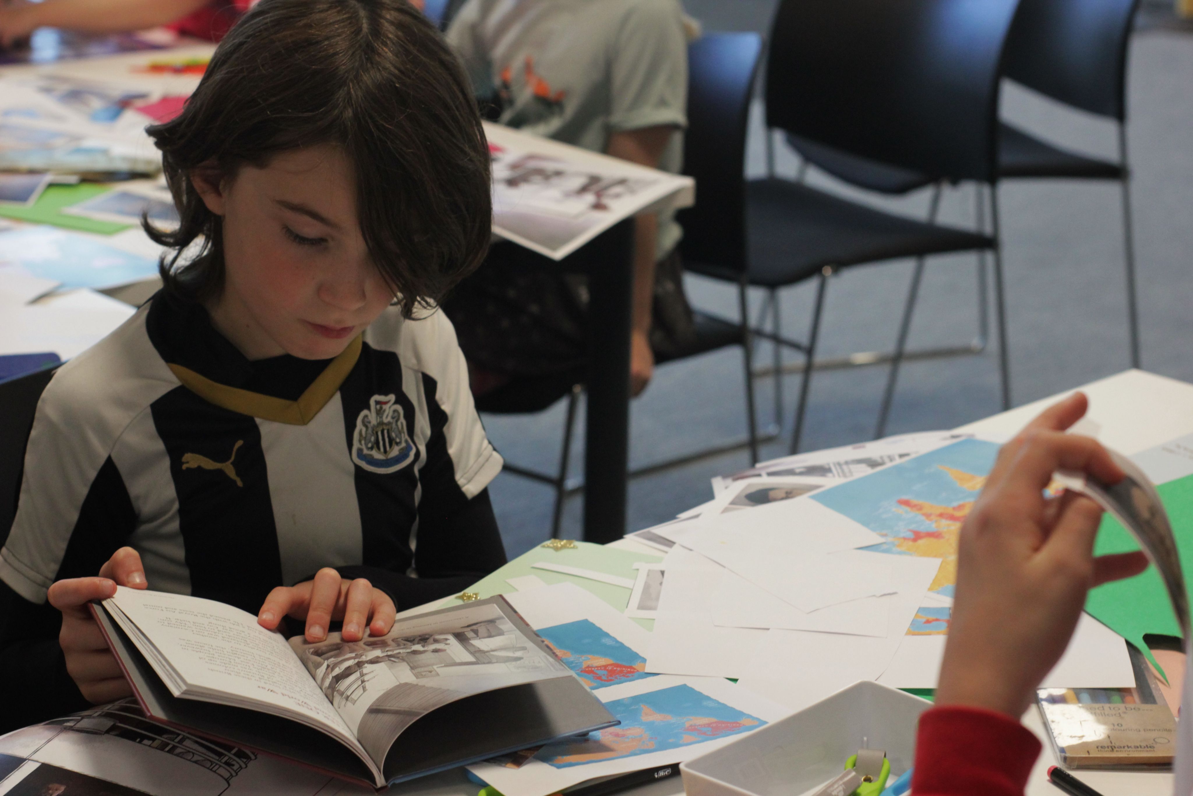 Image of a boy looking through a book