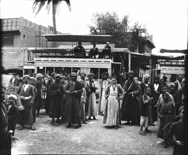 Photograph of townspeople and tram in Baghdad.